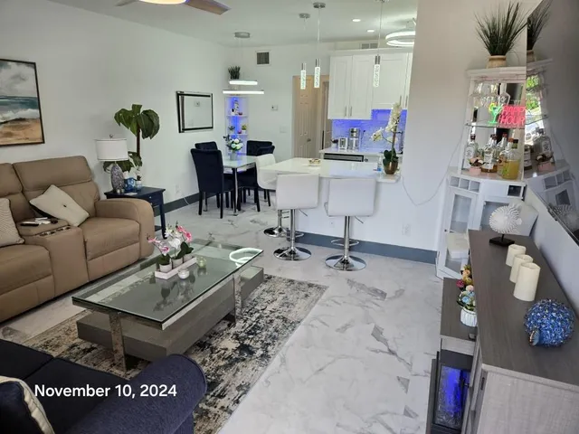 a living room with furniture and a dining table with wooden floor