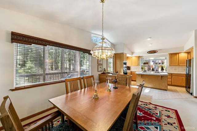 a dining room with furniture a chandelier and wooden floor