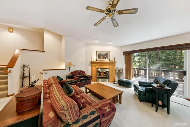 a living room with furniture a fireplace and a large window