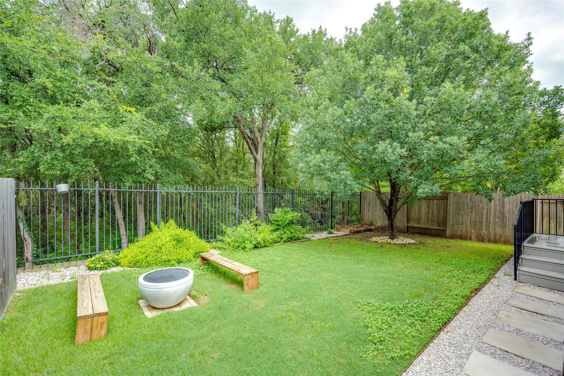 6008 Whipple Way Austin, TX 78745 - Photo 35 of 39 A private, verdant backyard sanctuary with a tranquil fire pit area and mature trees.