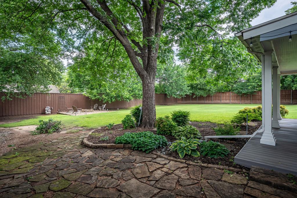 9121 6th Street Frisco, TX 75033 - Photo 2 of 27 a view of a garden with plants and large tree