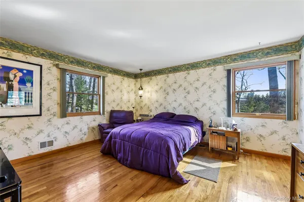 a bedroom with a bed and a large window with outer view