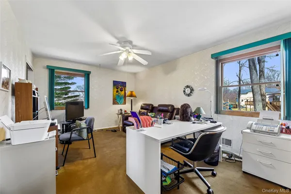 a view of a workspace with furniture and a window