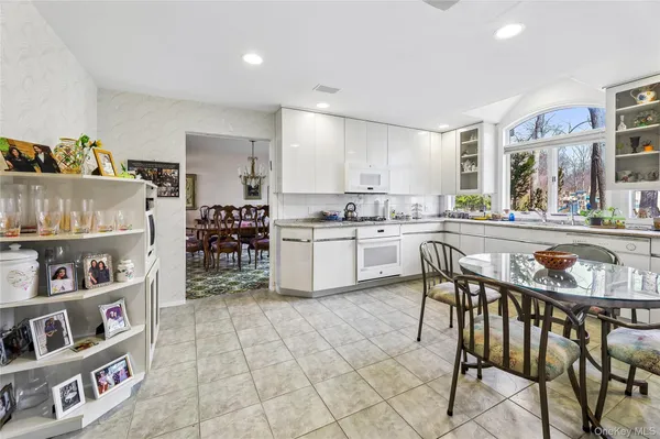a kitchen with stainless steel appliances a table and chairs in it