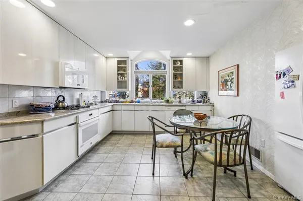 a kitchen with a sink chairs and cabinets
