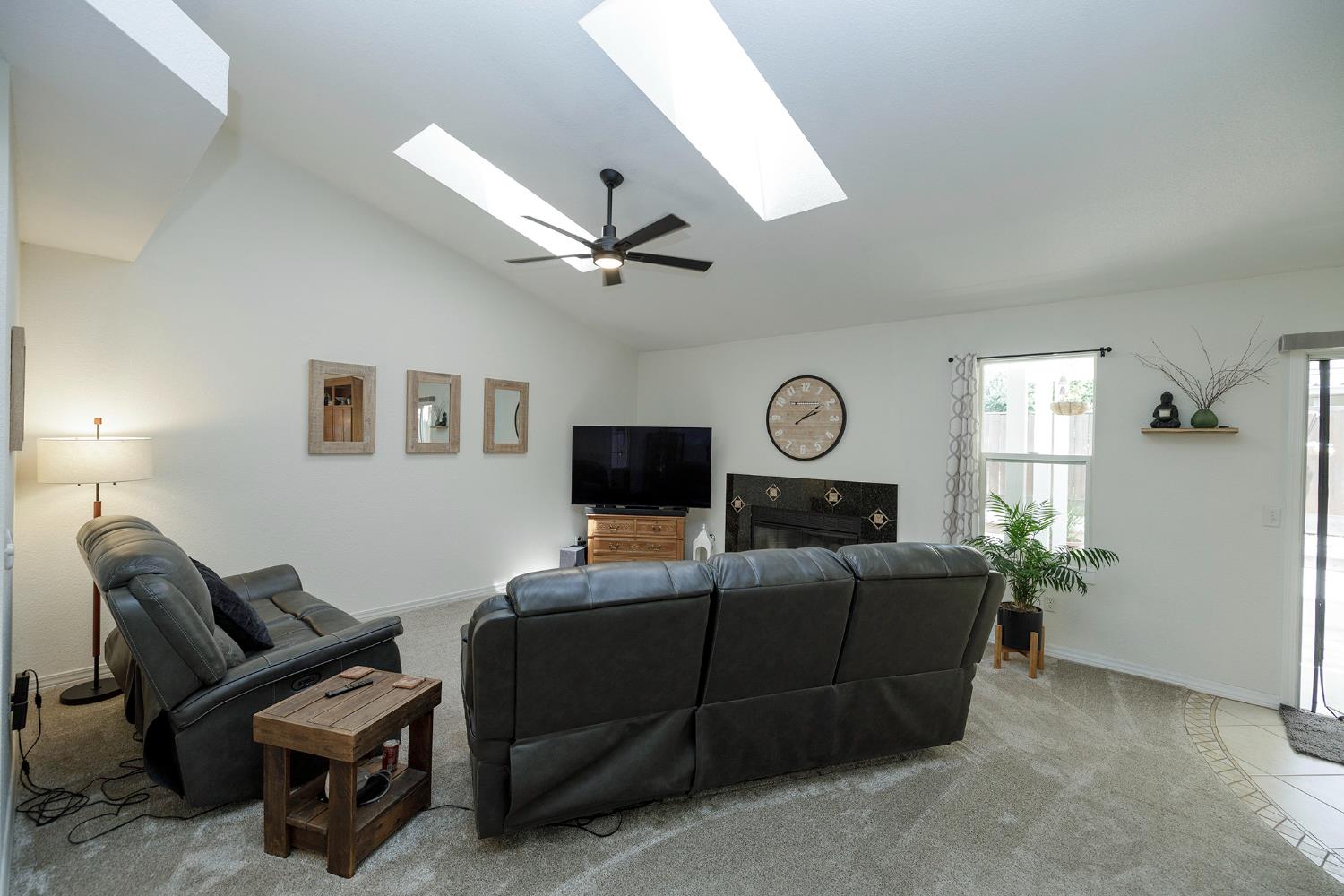 230 Meyenberg Avenue Ripon, CA 95366 - Photo 15 of 52 a living room with furniture a fireplace and a flat screen tv