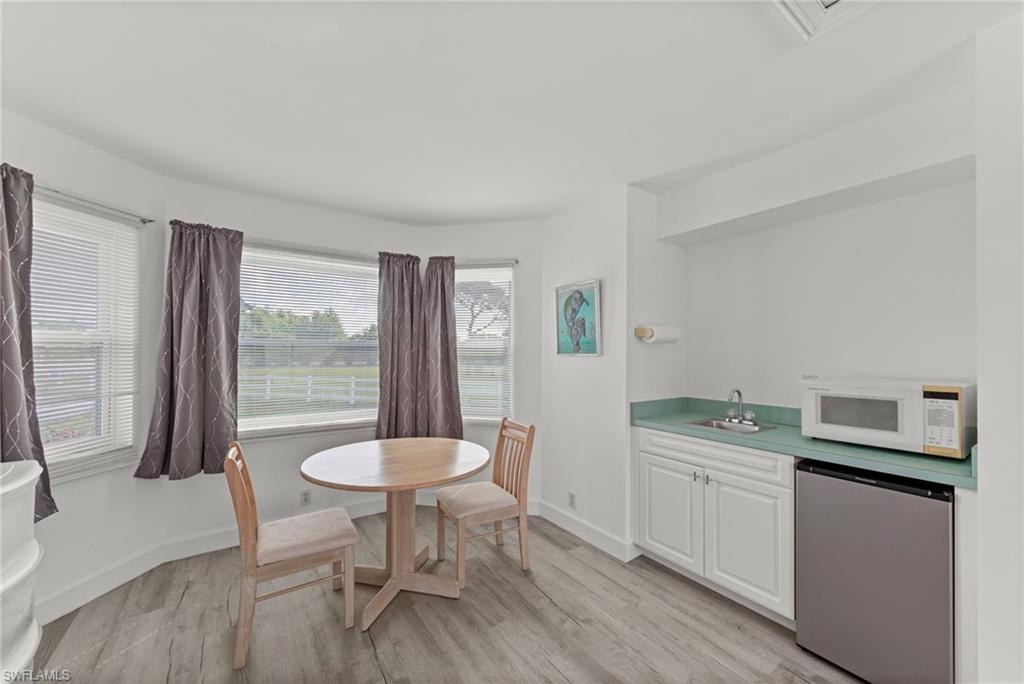 13541 Stringfellow Road Bokeelia, FL 33922 - Photo 25 of 49 a kitchen with a table chairs and a sink