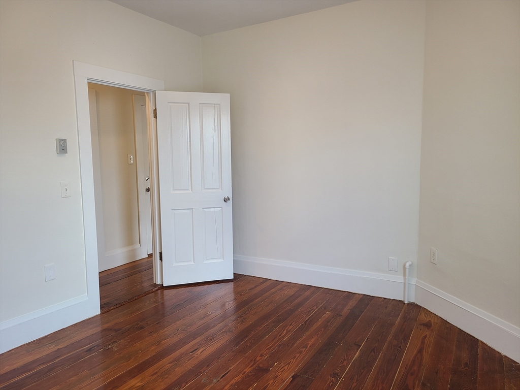 27 Buttonwood Street, Unit 3 Boston, MA 02125 - Photo 11 of 22 a view of an empty room with wooden floor