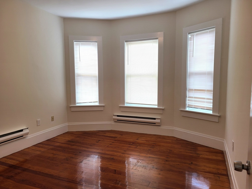 27 Buttonwood Street, Unit 3 Boston, MA 02125 - Photo 12 of 22 an empty room with wooden floor and windows