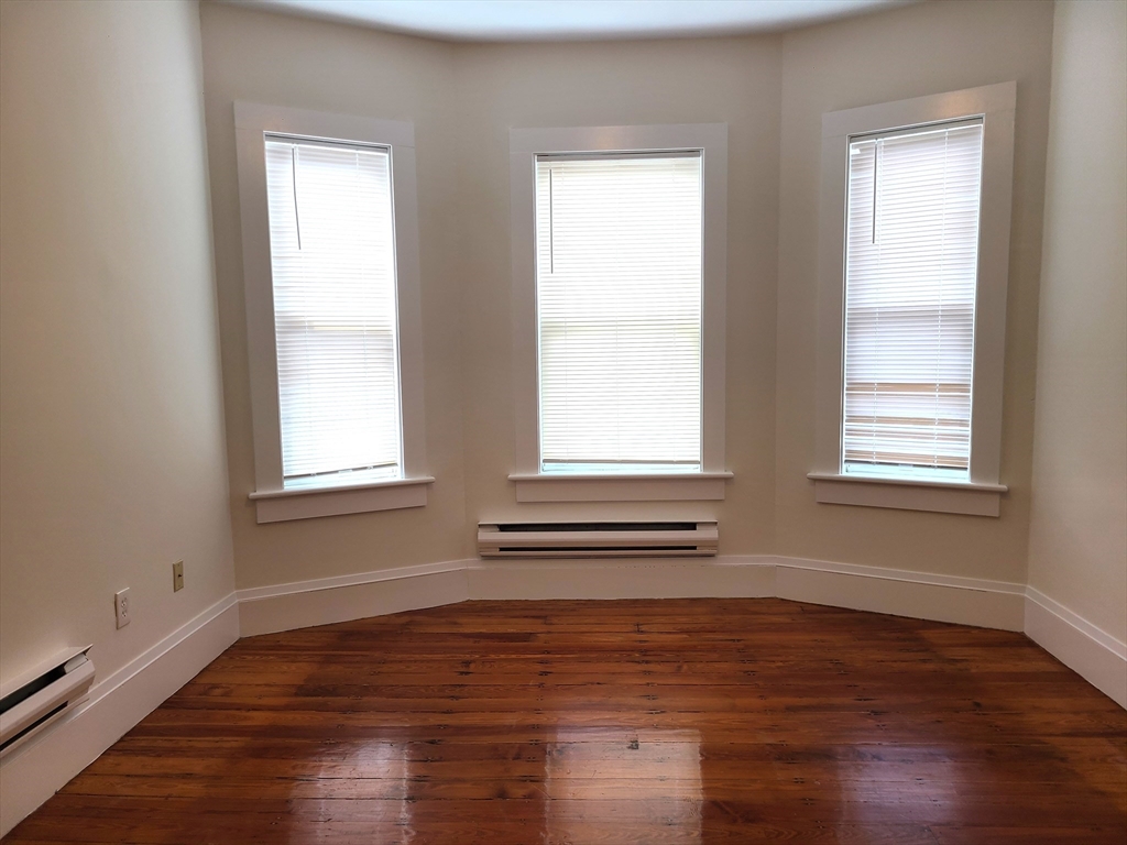 27 Buttonwood Street, Unit 3 Boston, MA 02125 - Photo 14 of 22 a view of empty room with wooden floor and fan