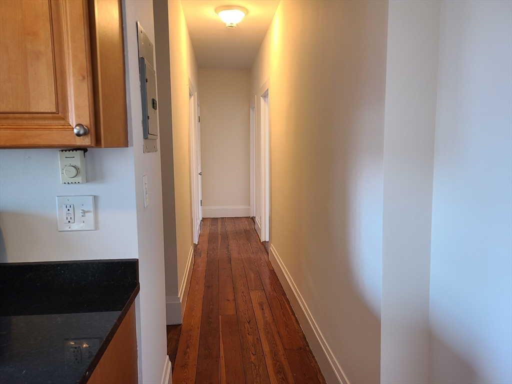 27 Buttonwood Street, Unit 3 Boston, MA 02125 - Photo 15 of 22 a view of a hallway with wooden floor and cabinets