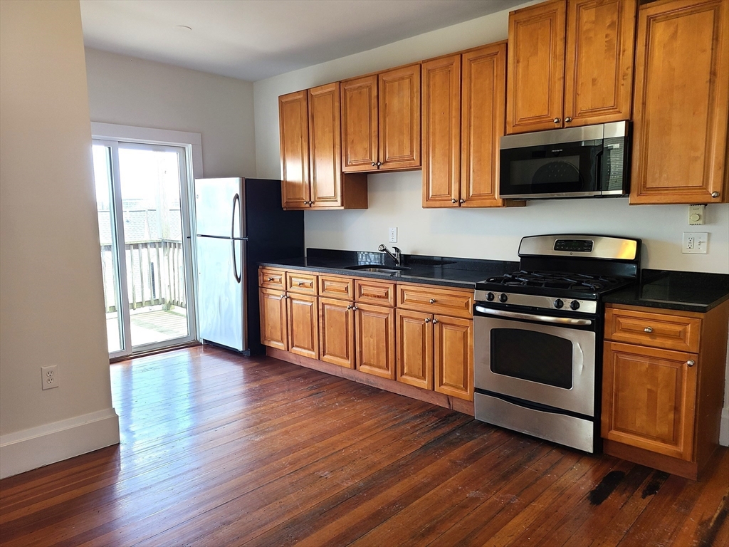 27 Buttonwood Street, Unit 3 Boston, MA 02125 - Photo 16 of 22 a kitchen with stainless steel appliances a stove a sink and a microwave