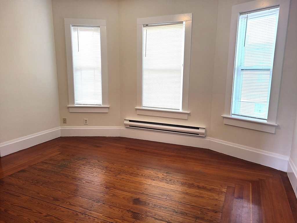 27 Buttonwood Street, Unit 3 Boston, MA 02125 - Photo 3 of 22 an empty room with wooden floor and windows