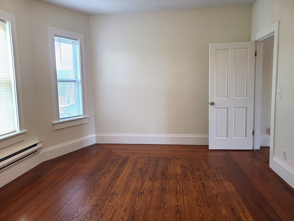 27 Buttonwood Street, Unit 3 Boston, MA 02125 - Photo 5 of 22 an empty room with wooden floor and windows