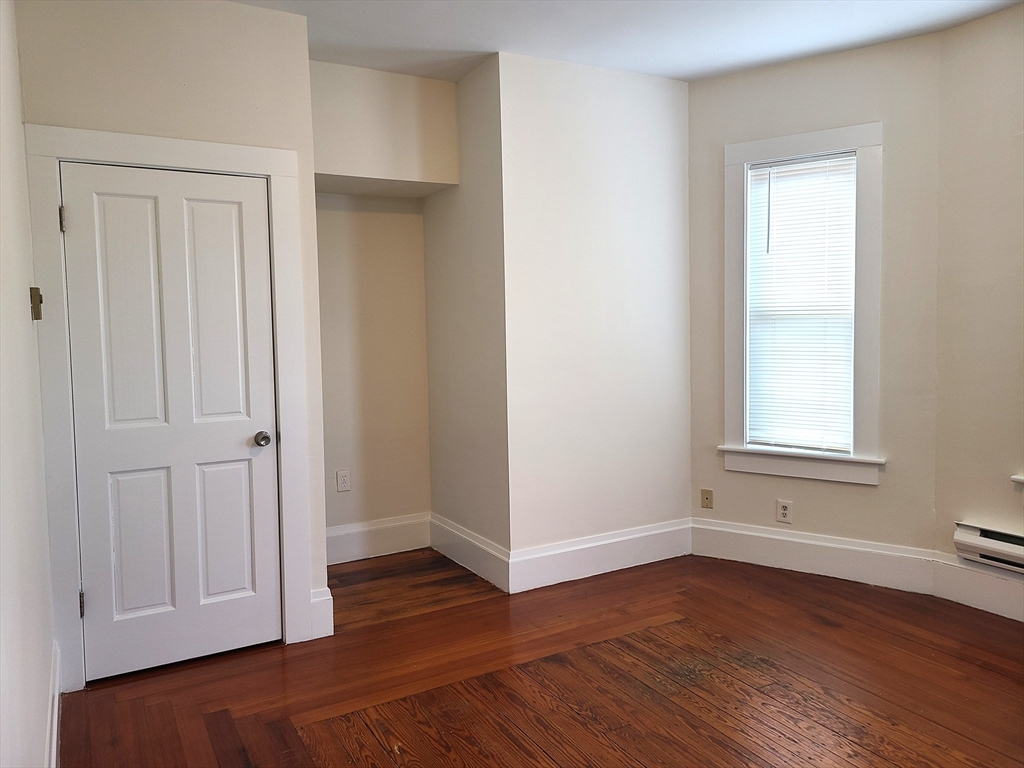 27 Buttonwood Street, Unit 3 Boston, MA 02125 - Photo 6 of 22 an empty room with wooden floor and closet area