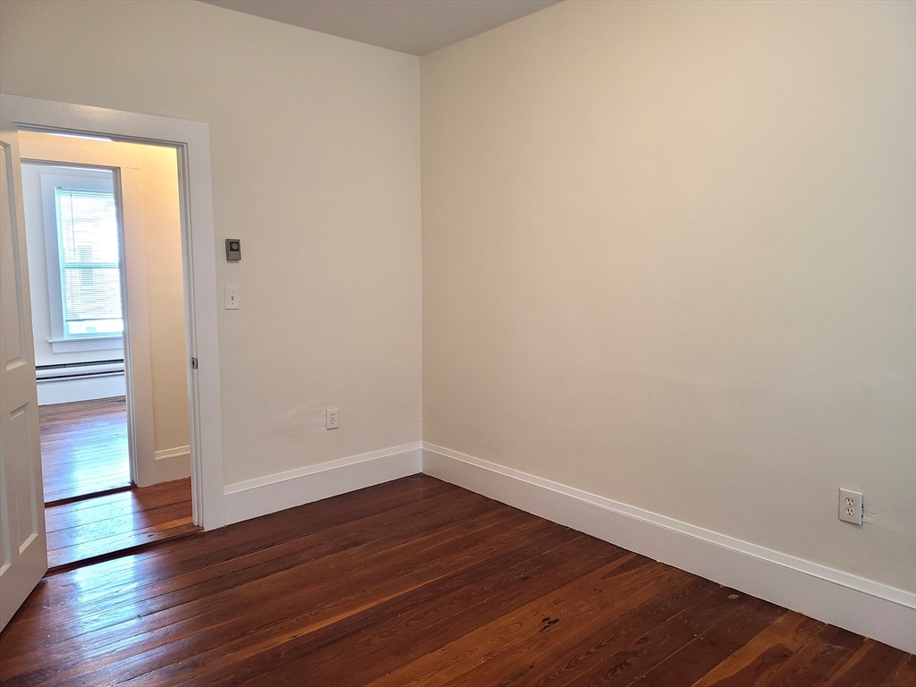 27 Buttonwood Street, Unit 3 Boston, MA 02125 - Photo 8 of 22 a view of an empty room with wooden floor and a window