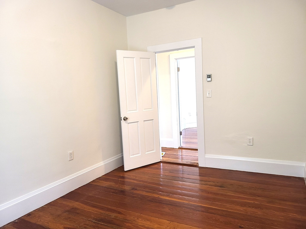 27 Buttonwood Street, Unit 3 Boston, MA 02125 - Photo 9 of 22 a view of an empty room with wooden floor