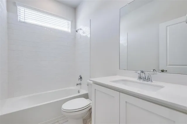 a bathroom with a granite countertop sink a toilet and shower