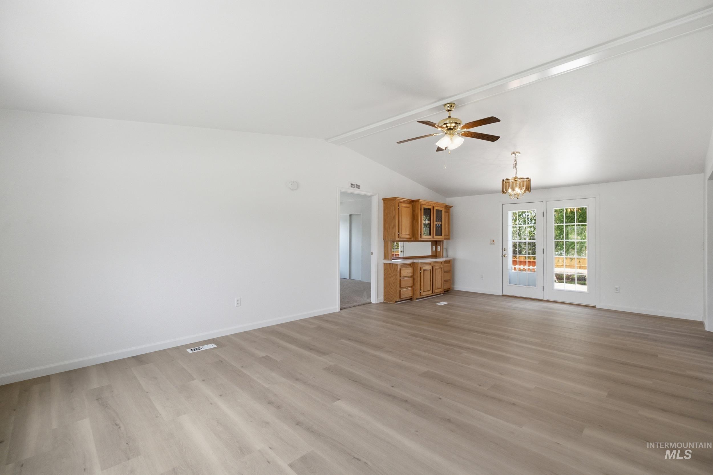 7422 Track Road Nampa, ID 83686 - Photo 13 of 50 Spacious room featuring vaulted ceilings, wood-finish flooring, a built-in cabinetry unit, and French doors