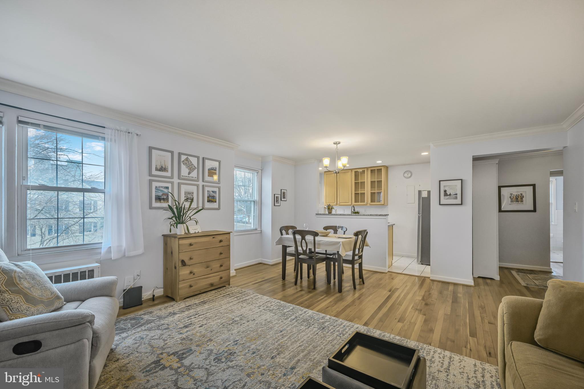 2402 Colston Drive, Unit 204 Silver Spring, MD 20910 - Photo 4 of 13 a living room with furniture a dining table and a wooden floor