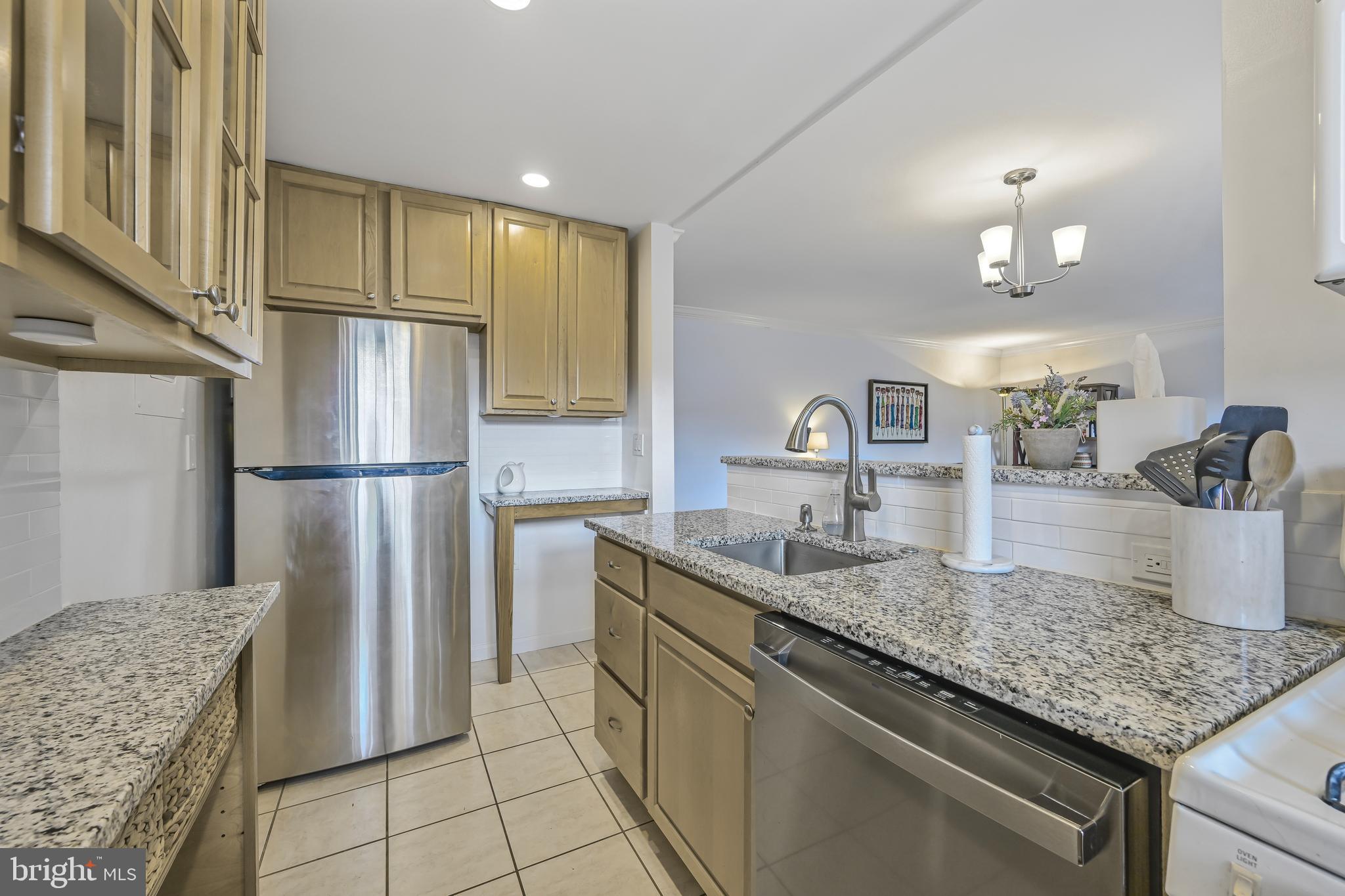 2402 Colston Drive, Unit 204 Silver Spring, MD 20910 - Photo 6 of 13 a kitchen with kitchen island granite countertop a refrigerator a sink and dishwasher