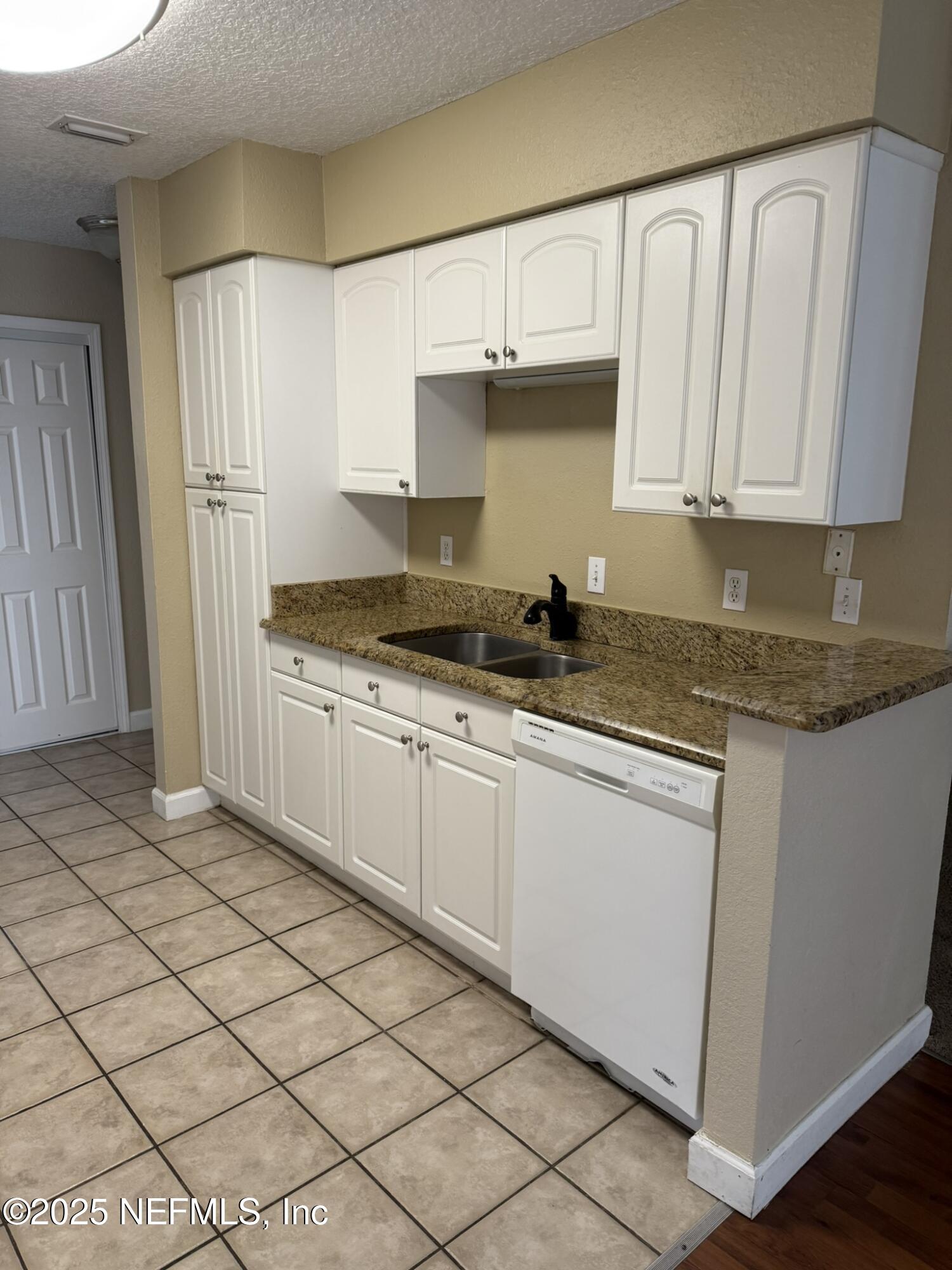 1800 Park Avenue, Unit 482 Orange Park, FL 32073 - Photo 3 of 10 a kitchen with granite countertop white cabinets and white appliances