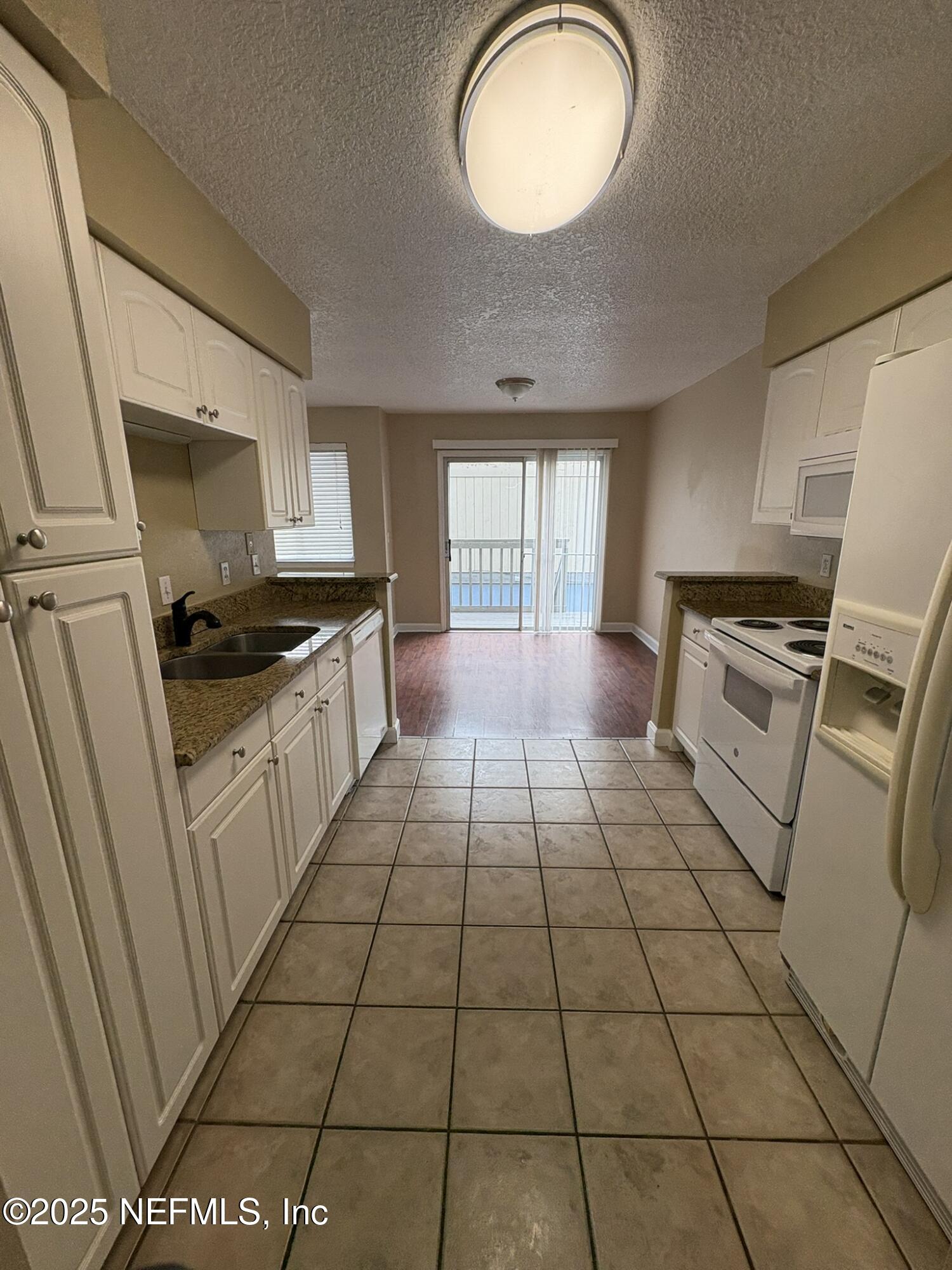1800 Park Avenue, Unit 482 Orange Park, FL 32073 - Photo 4 of 10 a kitchen with a sink a stove a microwave and cabinets