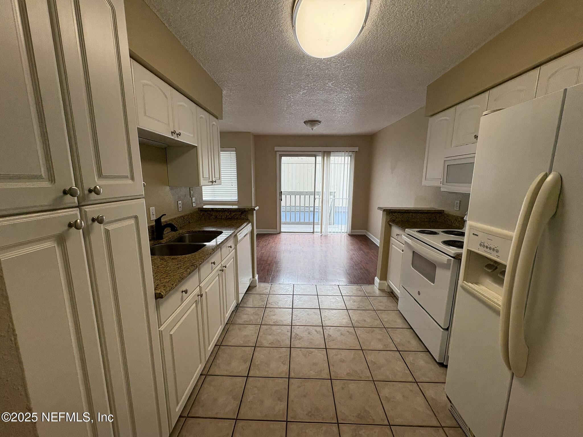 1800 Park Avenue, Unit 482 Orange Park, FL 32073 - Photo 5 of 10 a kitchen with a sink a refrigerator and cabinets