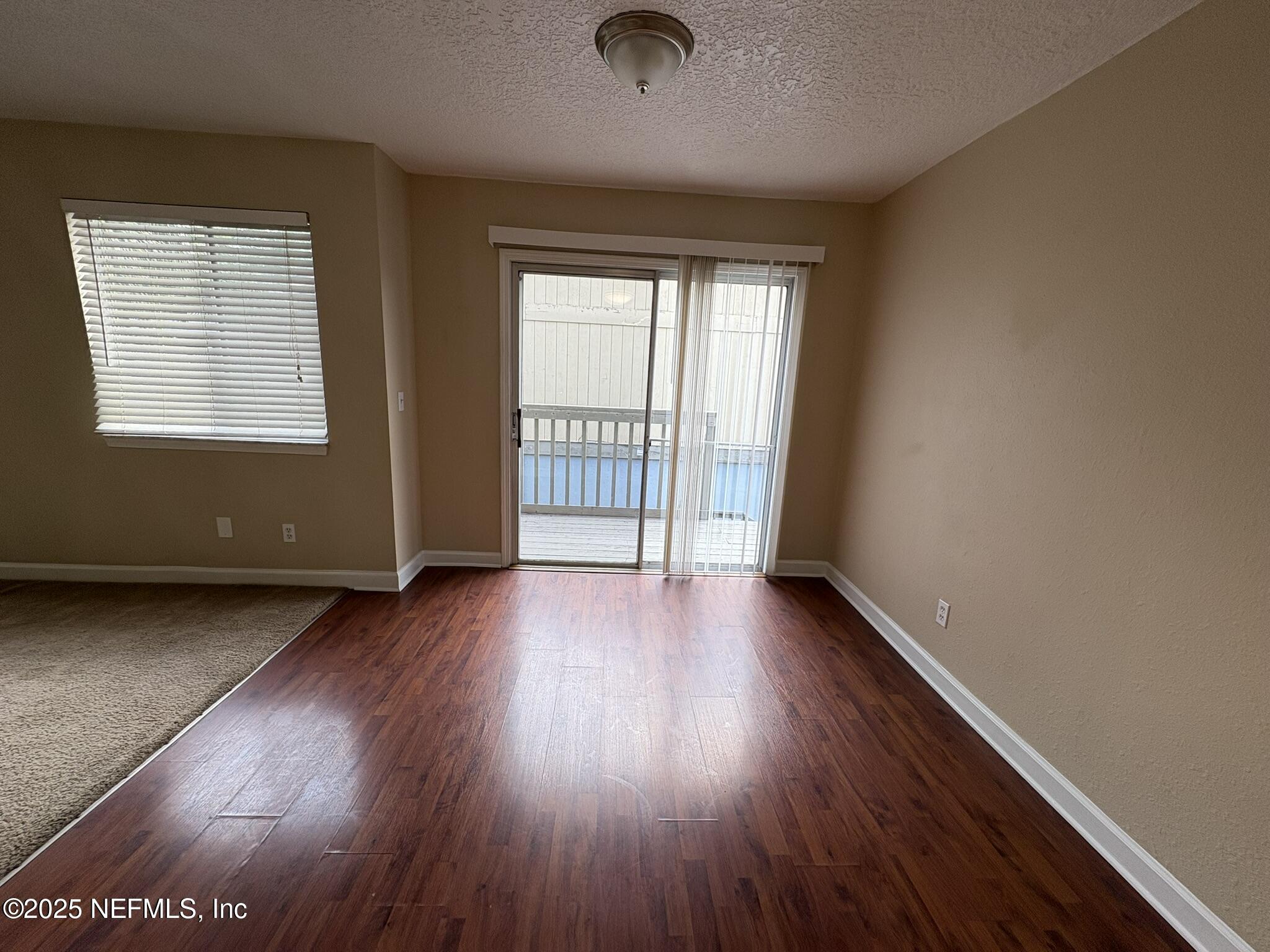 1800 Park Avenue, Unit 482 Orange Park, FL 32073 - Photo 6 of 10 an empty room with wooden floor and windows
