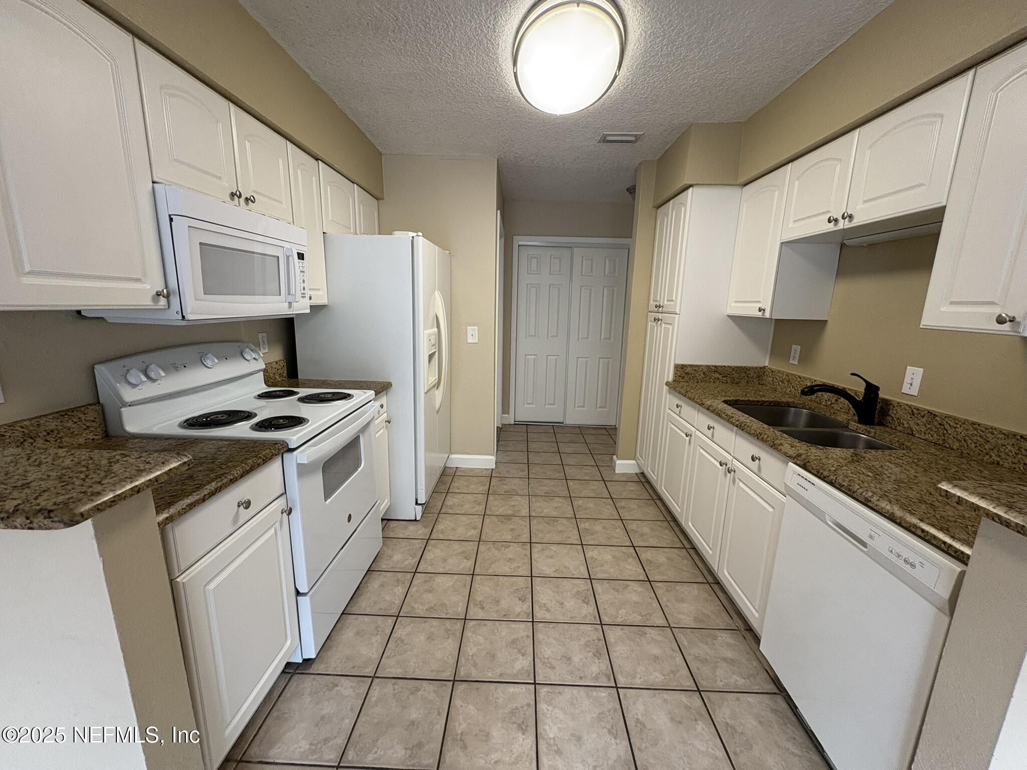 1800 Park Avenue, Unit 482 Orange Park, FL 32073 - Photo 7 of 10 a kitchen with a sink a stove and refrigerator