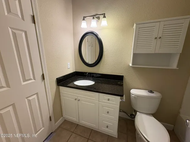 a bathroom with a toilet a sink and a mirror