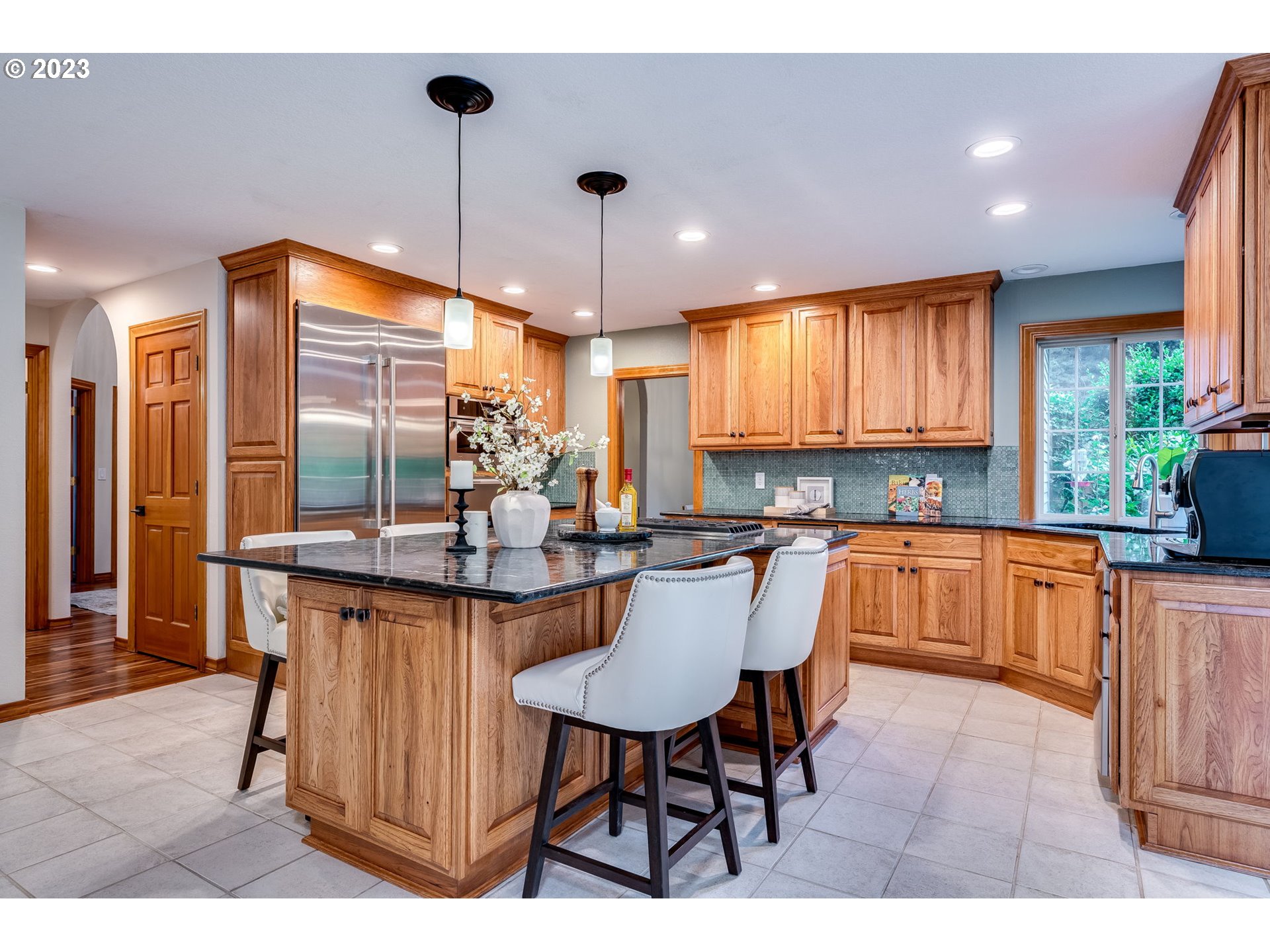 3200 Northeast Jackson Rd Loop Hillsboro, OR 97124 - Photo 11 of 37 a kitchen with granite countertop a table chairs stove a refrigerator and cabinets