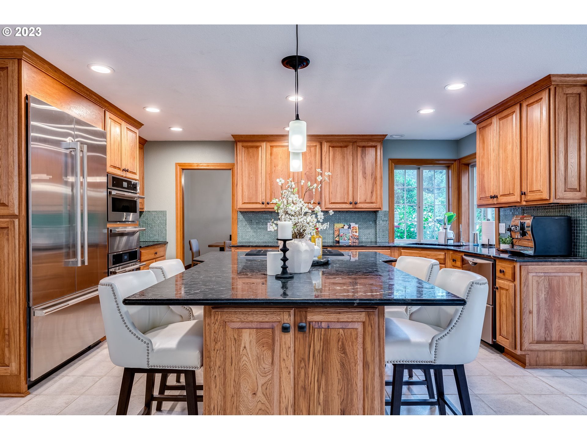 3200 Northeast Jackson Rd Loop Hillsboro, OR 97124 - Photo 12 of 37 a kitchen with stainless steel appliances granite countertop a kitchen island a stove a table and chairs in it