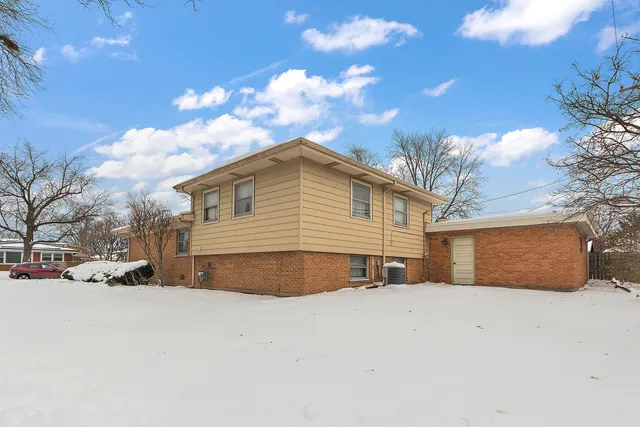 a view of large house with a yard covered in snow