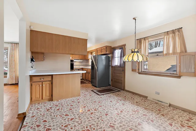 a kitchen with stainless steel appliances kitchen island granite countertop a refrigerator a stove and a sink with granite countertops