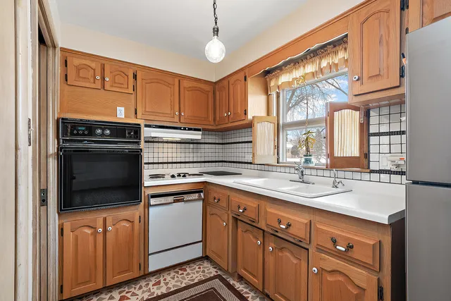 a kitchen with stainless steel appliances granite countertop a sink a stove and a refrigerator