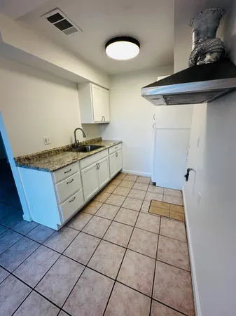 a kitchen with granite countertop a stove a sink and a granite counter tops