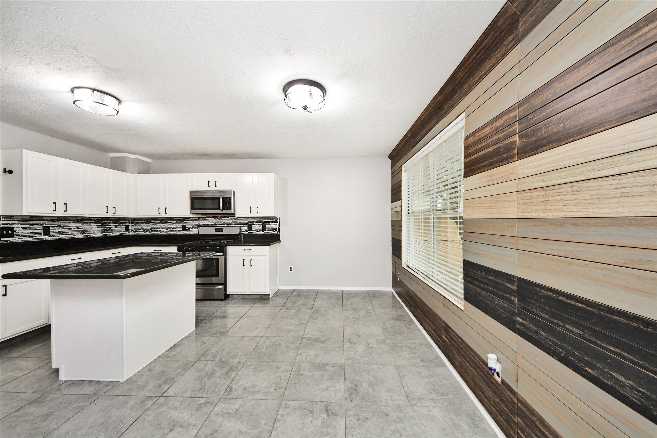 24019 Kingbriar Drive Spring, TX 77373 - Photo 18 of 41 A closer look at the kitchen's contemporary finishes, including the dark stone countertops and the clean lines of the white cabinetry and modern hardware.