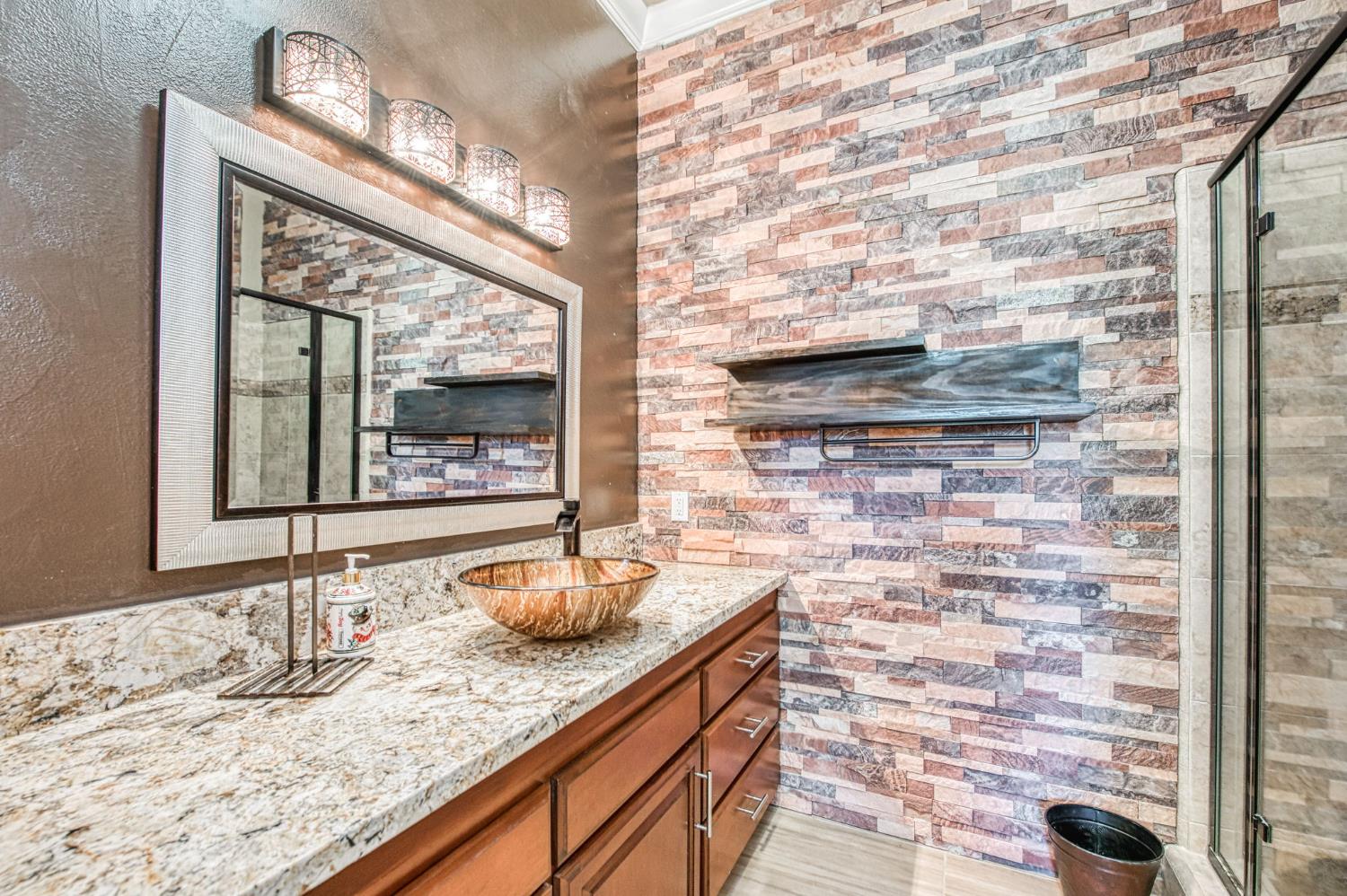 12629 Bronco Road Madera, CA 93636 - Photo 32 of 94 a bathroom with a granite countertop sink and a mirror