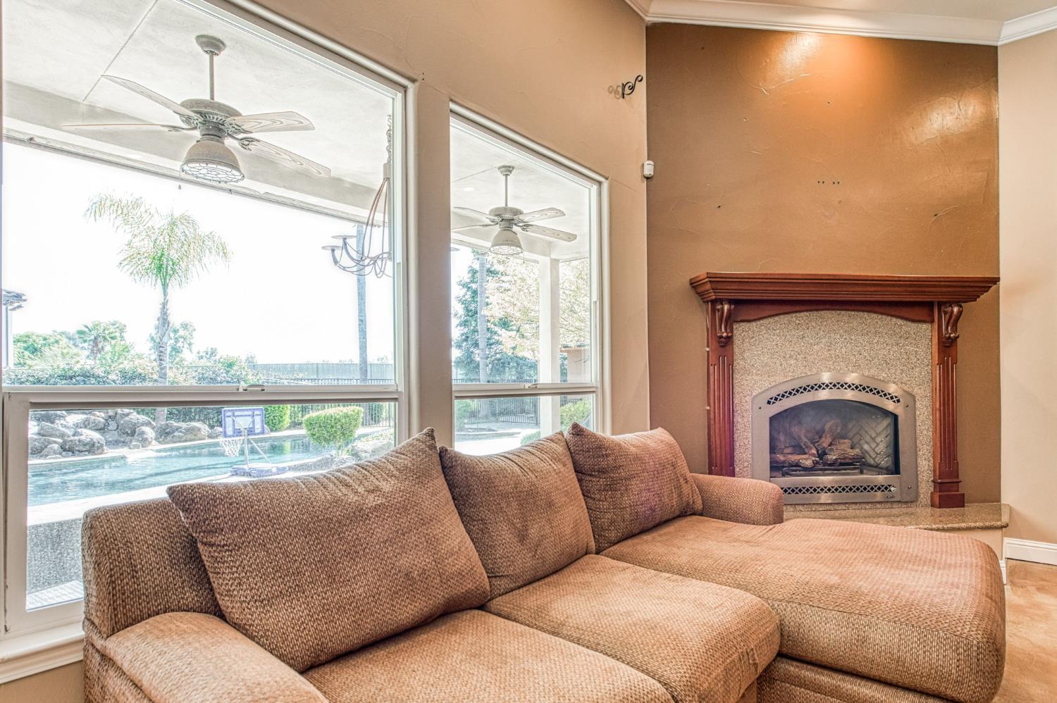 12629 Bronco Road Madera, CA 93636 - Photo 40 of 94 a living room with furniture a large window and a fireplace