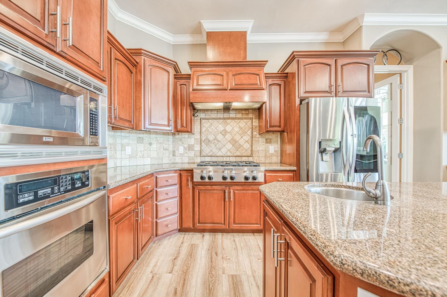 12629 Bronco Road Madera, CA 93636 - Photo 46 of 94 a kitchen with stainless steel appliances granite countertop a stove and a sink