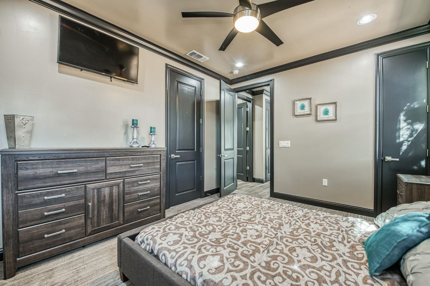 12629 Bronco Road Madera, CA 93636 - Photo 81 of 94 a spacious bedroom with a bed and a flat screen tv