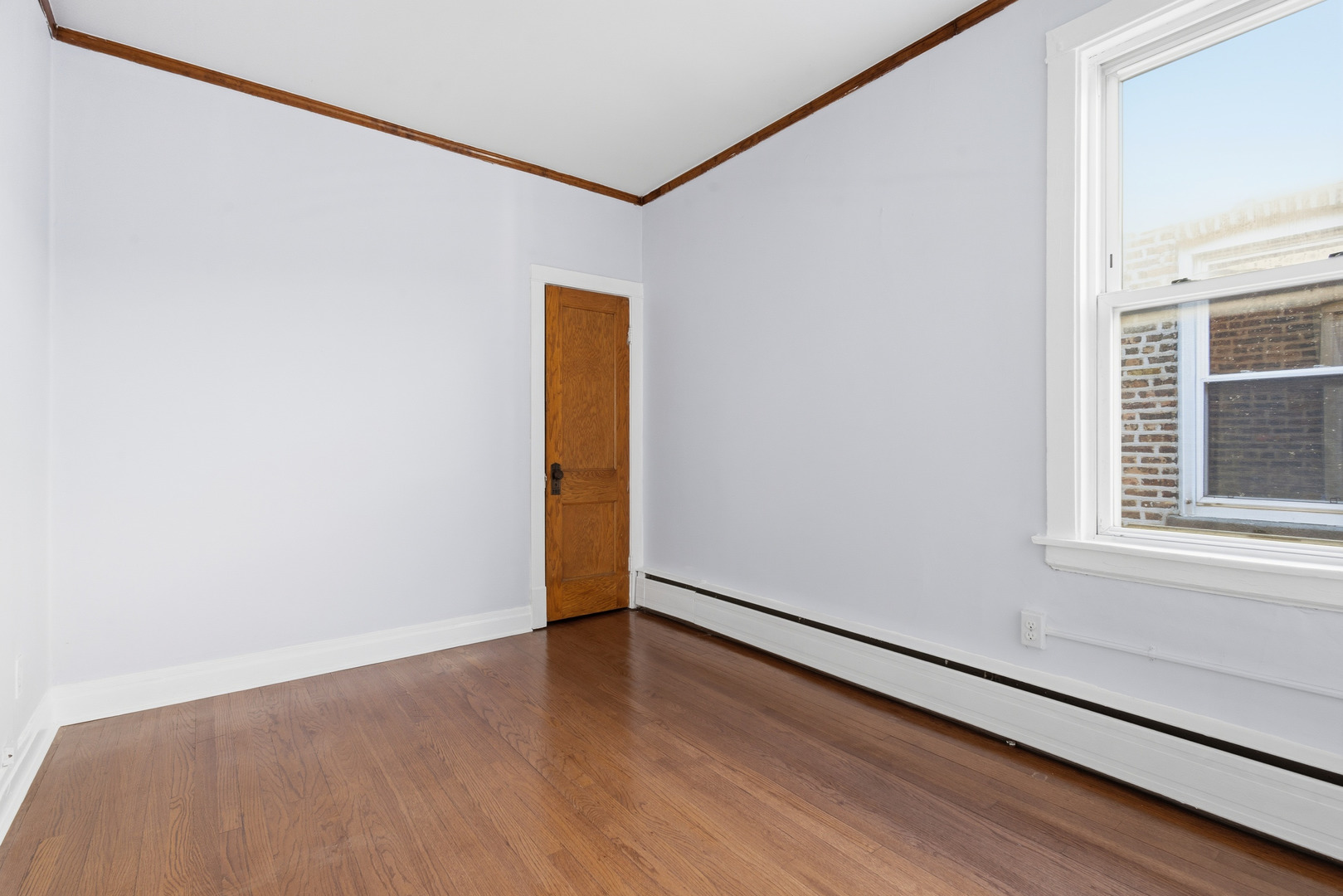 2102 South 50th Avenue Cicero, IL 60804 - Photo 11 of 53 a view of an empty room with wooden floor and a window