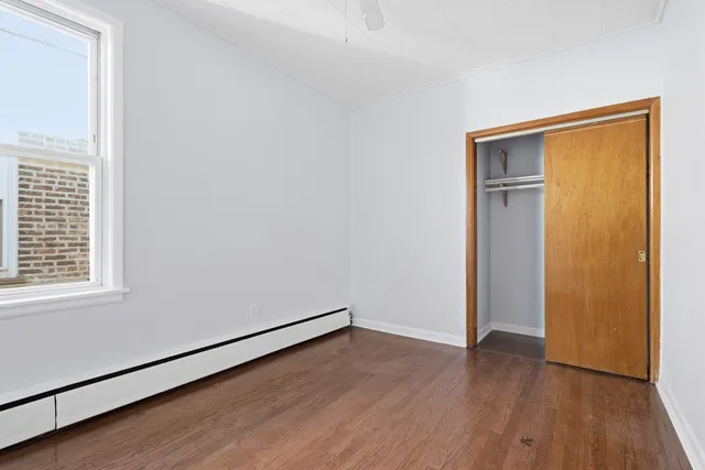 an empty room with wooden floor and closet