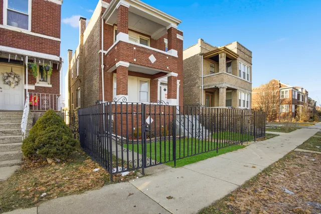 a view of a brick house with many windows next to a road