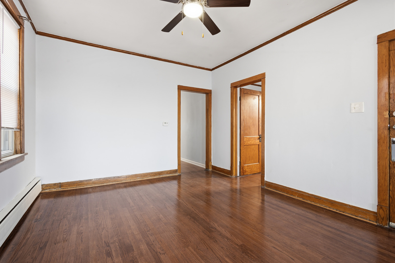 2102 South 50th Avenue Cicero, IL 60804 - Photo 4 of 53 a view of an empty room with wooden floor and a window
