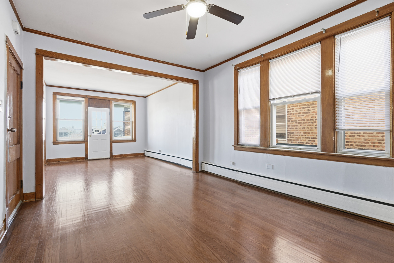 2102 South 50th Avenue Cicero, IL 60804 - Photo 6 of 53 a view of an empty room with wooden floor and a window