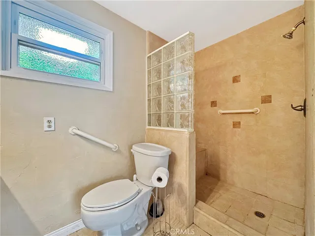 a bathroom with a toilet and a shower