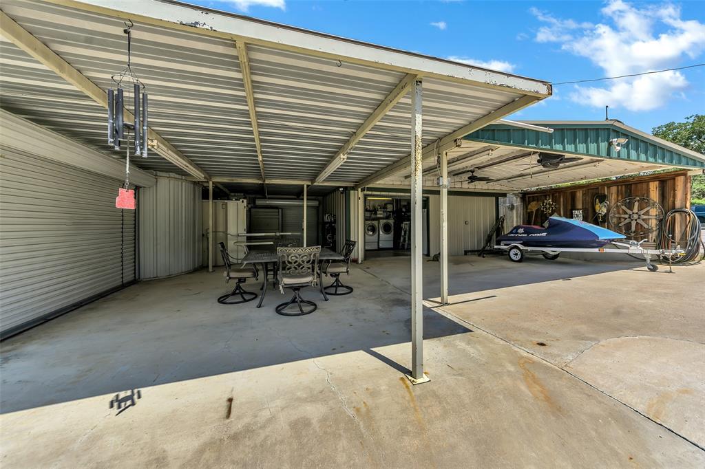 566 Selma Park Road Bowie, TX 76230 - Photo 30 of 40 Expansive covered concrete patio featuring a dining area, an outdoor laundry station, and additional covered parking