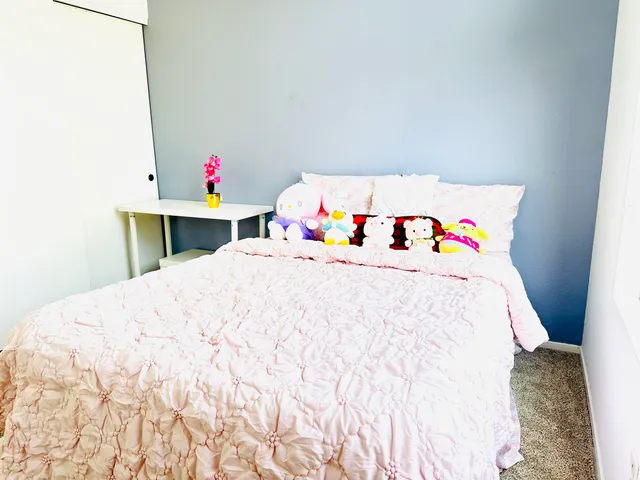 a bedroom with a bed and painting on the wall